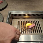 焼肉うしごろ - 熊本県産のA5厚切りサーロインを、網の鉄板の上で焼いている様子のその6です。