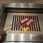 焼肉うしごろ - 熊本県産のA5厚切りサーロインを、網の鉄板の上で焼いている様子のその2です。