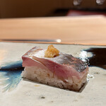 鮨 つぼみ - 鯵の押し寿司（冷やしての提供）
      川口大将のこれ、めちゃくちゃ美味しい！
      ひんやりした押し寿司、鯵の身がしっとりとして脂が落ち着いた塩梅、合わせる生姜の風味良く絶品です♪