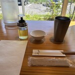 麺や句來夢 - 紙エプロン、味変用の柚子オイル、貝殻入れ小皿、お冷コップ