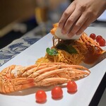 PRIMONTE SARAHAMA - 料理写真:大迫力の「伊勢海老パスタ」島唐辛子の効いたベースの味わいがあり、テーブルで身がゴロゴロ入ったアメリケーヌソースで仕上げて下さいます。