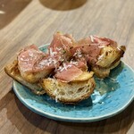 ニンニクバル にょんにょご - ■お通し ¥440・ブルスケッタ、デニッシュにニンニクオイル＆生ハム 