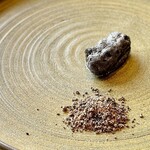 プレゼンテ スギ - 人参の向こう側。人参を余すことなく使用したシェフ渾身の一品。墨パウダーの薄衣を纏った中身は外側サクッと中はもっちり！ブラックオリーブとシナモンシュガー添え。