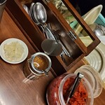 辛激屋 - 卓上。福神漬､アーモンドオイル､付け合せのキャベツのピクルス。