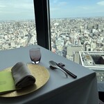 広東料理 センス - 窓越しに広がる都市景観と洗練された空間が調和し、静謐で上質な雰囲気の中で贅沢な食事体験を演出する内観。