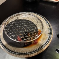 赤身焼肉 かるびあーの 新橋店 - 網に挟まったり、網の下に落ちたユッケ