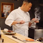 322573707 - 大将が備長炭でネタを手に持って炙っていますが、指を炙りそうで見てられません