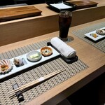 川崎 鮨 よこ田 - カウンター。台の上のお皿に、鮨、天ぷらが提供される。