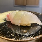 鮨 はま岡 - ハタ、黒い陶器の上には赤酢シャリのネタが載ります