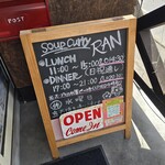 スープカレー RAN - お店情報が書かれたサインボード（階段を上がった入口前）