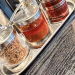 支那ソバ 小むろ - 卓上調味料(左から、揚げネギ・一味唐辛子・胡椒)