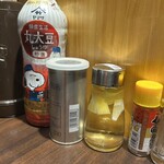 寿製麺 よしかわ 西台駅前店 - 木製の衝立てで一席一席仕切られています　胡椒と七味の間の液体はレモン酢です