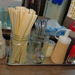 麺飯食堂 めしきんぐ - テーブル席の調味料、割り箸、スプーンなど