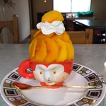 嘘と僕 - 人の顔した容器に、かき氷、その上に『梶屋柿農園(和歌山)』さんの薄くスライスされた『ひらたね柿』がたっぷり盛りつけられている〜!! その上にエスプーマクリームとひらたね柿〜!!( ^o^)ﾉ