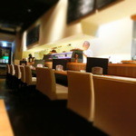 ゆったりとしたカウンター席が厨房に向かって並んでいる。