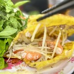 GIA DINH - バインセオの粉（原材料：米粉、小麦粉、ターメリック）を溶いて薄く焼いた間に、たっぷりの炒めモヤシ、豚ひき肉、海老を包んであります。