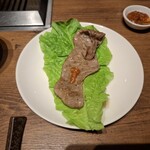 焼肉うしごろ - 網の鉄板で焼いた鹿児島県産の大判サーロインを、ポン酢に浸けた後サムジャンと一緒にサンチュの上にのせたもののその1です。