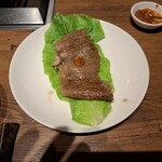 焼肉うしごろ - 網の鉄板で焼いた鹿児島県産の大判サーロインを、ポン酢に浸けた後サムジャンと一緒にサンチュの上にのせたもののその2です。