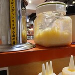 油そば鈴の木 - カウンター上のニンニク、粉チーズがありました。