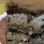 チョコレートショップ 博多の石畳 - チョコスポンジの上に、チョコム一ス、バニラスポンジ、生クリームとガナッシュクリームで仕上げ、薄いチョコレートでコ一ティングされている。