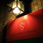 BRILLANTE IL SUZUKI - 壁に掛けられた真っ赤な看板が目印