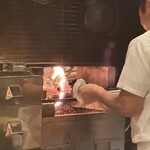 くずし 之助 - 鰹藁焼き中。店内に良い香りが広がる。