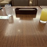 ロイヤルホスト - お冷とおしぼり、ドリンクバーのオレンジジュースです。