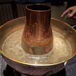 瀬里奈 - しゃぶしゃぶのスープで、水沢うどんを調理している様子です。