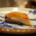 立喰すし魚河岸 山治 - ◇穴子（対馬）
煮詰めのほろ苦さと甘みが柔らかな身を引き立てながら、シャリとナチュラルに同化。そしてそっと口溶ける。