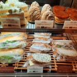 ブーランジェリー ブルディガラ - 冷蔵ショーケースにはサーモンや本格チーズを使ったサンドもあれば、人気パティスリーのプティ・ガトーも（その2）