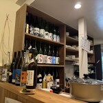 旬菜と地酒 野良 - カウンターの中の棚のお酒は常温〜燗で、ということらしい