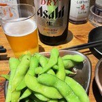 酉どうらく - お通しの枝豆とスーパードライ中瓶