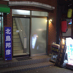 雑居ビルの入口としか思えない。知らなければ、この扉を開けるのにも勇気が必要。