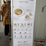 麺処 ゆずラボ｡ - 階前に設置された写真付きメニュー