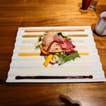 飛騨牛グリルばくろ - ◯朝摘み取れたてガーデンサラダ
            ～8種のフレーヴァ―ソースで～
            
            野菜の盛り合わせの下には皿のギザギザに合わせて
            8種類のフレーバーソースがストライプで敷かれていた