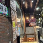 韓味 - レンガの外壁と控えめな照明が印象的な入口。