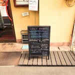 ビストロ コゥジィ - 玄関扉横のランチメニュー。