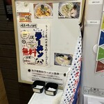 暗黒中華そば 雷電 - 券売機の横に「ラーメン屋は世界を救うことができない」というメッセージとともに、お子様無料ラーメンの食券が置いてあります。