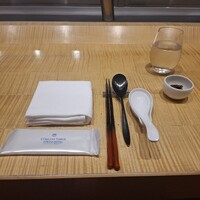 スーツァン・レストラン陳 渋谷店 - カウンター席のナプキン、お手拭き、箸、スプーン、れんげ、お冷、ナッツの飴炊きです。