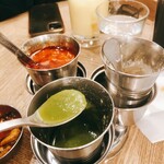 エリックサウス 高円寺カレー＆ビリヤニセンター - 卓上アイテム 手前がグリーンチリソース 左は漬物 右は謎粉。笑