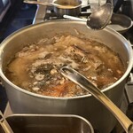 BAR EL PEPE - パエージャのスープを炊いています。お魚がたくさん入っています。