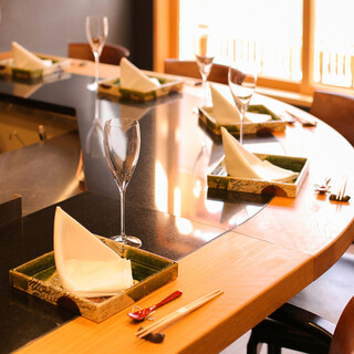 カーブしたカウンターが生む一体感で団体でも心地よく語らえます。