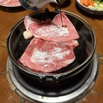 豚捨 - 牛脂をなじませた鉄鍋に牛肉を置き、砂糖を振り、醤油をかける