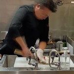 炉ノ鳥 - 生け簀から網でヒラメをすくい上げ、手際よく捌く職人さん