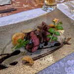 Une Fleur - 鹿ヒレ肉：鹿ヒレ肉のしっとりとして 弾力のある食感はそのままに、深い旨みを感じられる綺麗なミディアムレアに仕上げられています。 秋トリュフ ＆ 菊芋のチップスと共に 美しく盛り付けられています。