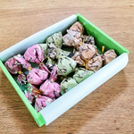 西宮名塩サービスエリア （上り線） ショッピングコーナー - 橙の巾着にはミルク・ホワイト・モカ、緑の巾着にはダーク・ミルク・抹茶、桃の巾着にはクランベリー・キャラメル・ミルク