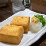 一押しの自家製”厚揚げ”は表面の硬めの食感と、中のとろける感じのギャップが絶妙。旨味が詰まった一品で、大根、生姜、ネギを添えていただく。