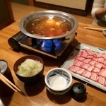 あやとり - 鍋が温まり肉や薬味が到着。白葱はどっさり使うのが吉。柚子胡椒もイイ辛さで名脇役。秘伝のたれは主張こそしないけど、円やかで落ち着いた味わい♫