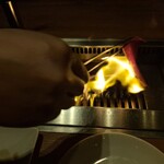 焼肉うしごろ - 栃木県産の上ミスジを、網の鉄板で焼いている様子のその4です。これまた、見事なファイアーダンスを繰り広げてます。
