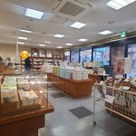 もち吉 - 白い天井、ガラス張り壁&白壁、白いタイル&黒いタイル貼り床、木製の陳列台には沢山のお煎餅やあられが並んでおり、そして一角にはソフトクリームの窓口があります
但し店内での飲食は不可、テイクアウトのみ